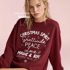 A woman wearing 'CHRISTMAS SPIRIT Gratitude PEACE Love MAGIC & HOPE Sprinkle with Joy' unisex sweatshirt.

Original design and copyright by first row LA August 10th, 2026.