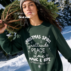 A woman wearing 'CHRISTMAS SPIRIT Gratitude PEACE Love MAGIC & HOPE Sprinkle with Joy' unisex sweatshirt.

Original design and copyright by first row LA August 10th, 2026.