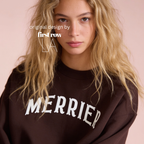 A woman wearing a bright pink crewneck sweatshirt with 'MERRIER' printed in white arched letters across the chest.

Original design and copyright by first row LA, August 11th 2026.