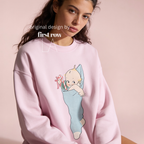 A woman wearing a Christmas sweatshirt with a Kewpie cartoon baby graphic.

Original design and copyright by first row LA, august 12th 2026.
