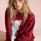 A woman wearing a Christmas sweatshirt with a Kewpie cartoon baby graphic.

Original design and copyright by first row LA, august 12th 2026.