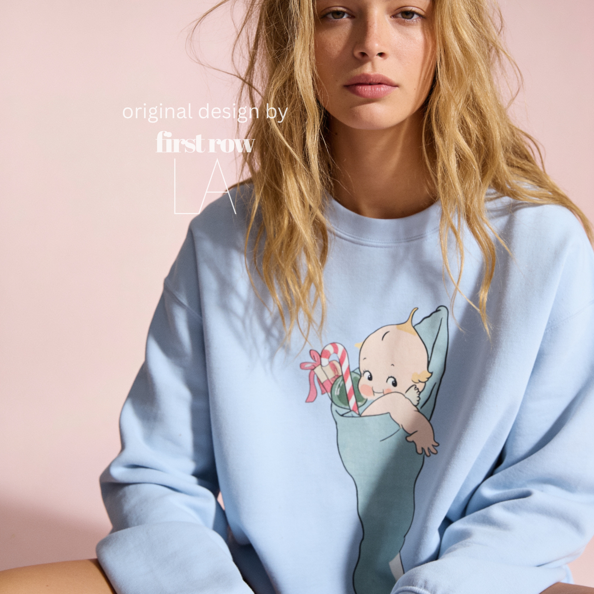 A woman wearing a Christmas sweatshirt with a Kewpie cartoon baby graphic.

Original design and copyright by first row LA, august 12th 2026.