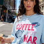 Woman wearing Make Coffee Not War TShirt, Peace Coffee Tee, Moka Pot Graphic Tee, Coffee Lover Shirt, Anti War Tee, Espresso T, Barista, Cute Coffee Shirt.

Original design and copyright by first row LA 2026.