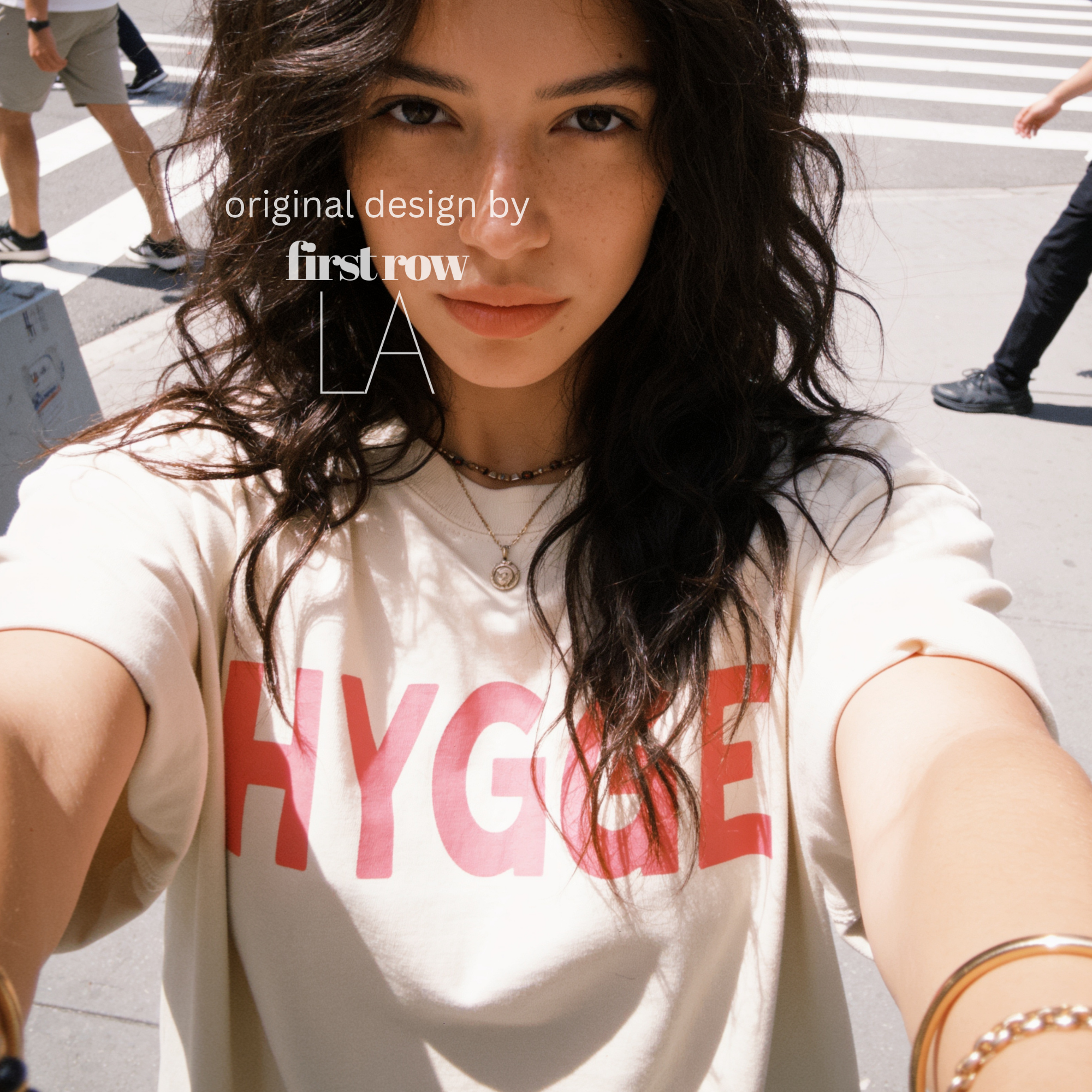 Woman wearing HYGGE T-shirt  with  large pink hand drawn letters.

Original design and copyright by first row LA Aught 18th, 2026.