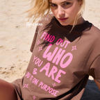 A woman wearing aT-shirt with bright pink text that reads 'FIND OUT WHO YOU ARE & DO IT ON PURPOSE'.

Original design and copyright by first row LA August 26th, 2026