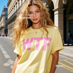 A woman wearing a butter yellow T-shirt with large pink 'WTF' print.

Original design and copyright by first row LA 2026.