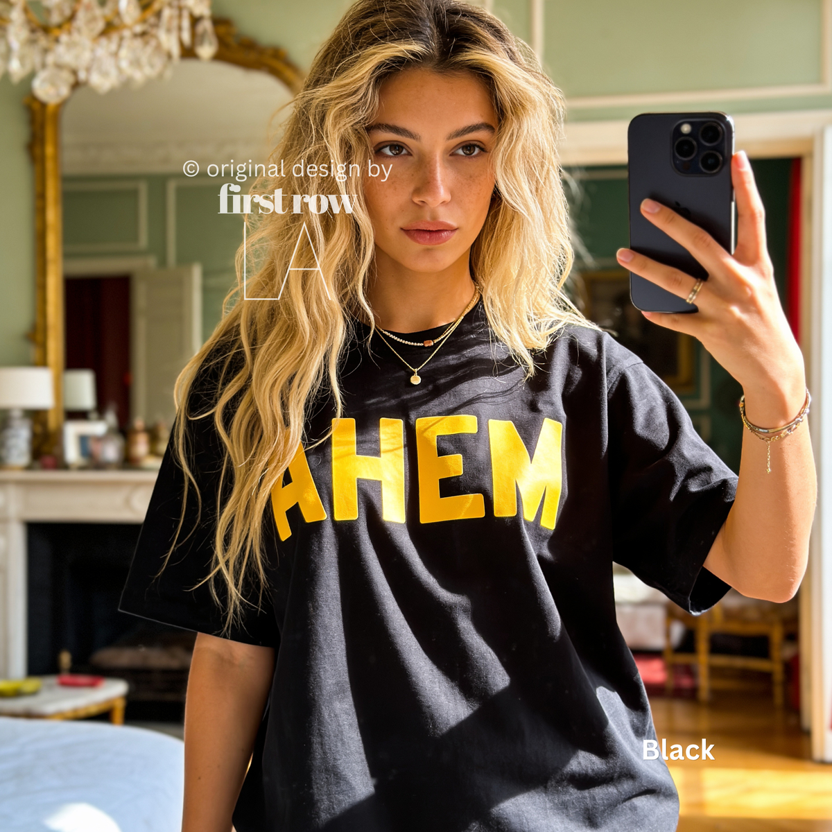 A woman takes a mirror selfie wearing an oversized black t-shirt with the word 'AHEM' printed across the chest in bold yellow letters.

Original design and copyright by first row LA, August 4th 2026.
