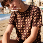 A woman wearing a brown short-sleeve t-shirt with a repeating beige lip print.

Original design and copyright by first row LA.