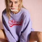 A woman wearing a lavender crewneck sweatshirt with a red 'Ciao!' graphic on the front.

Original design and copyright by first row LA.