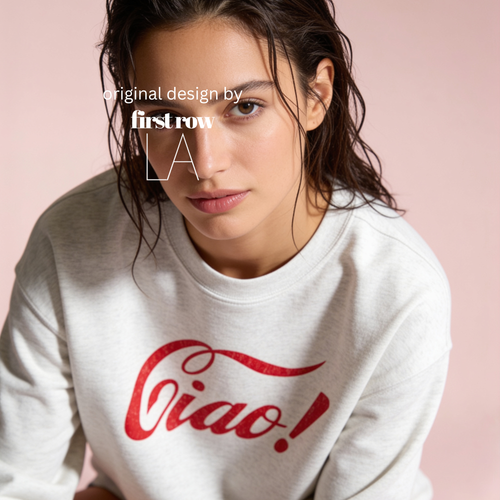 A woman wearing a light gray sweatshirt with a red distressed 'Ciao!' graphic on the front, posed against a soft pink background. Text overlay reads 'original design by firstrow LA