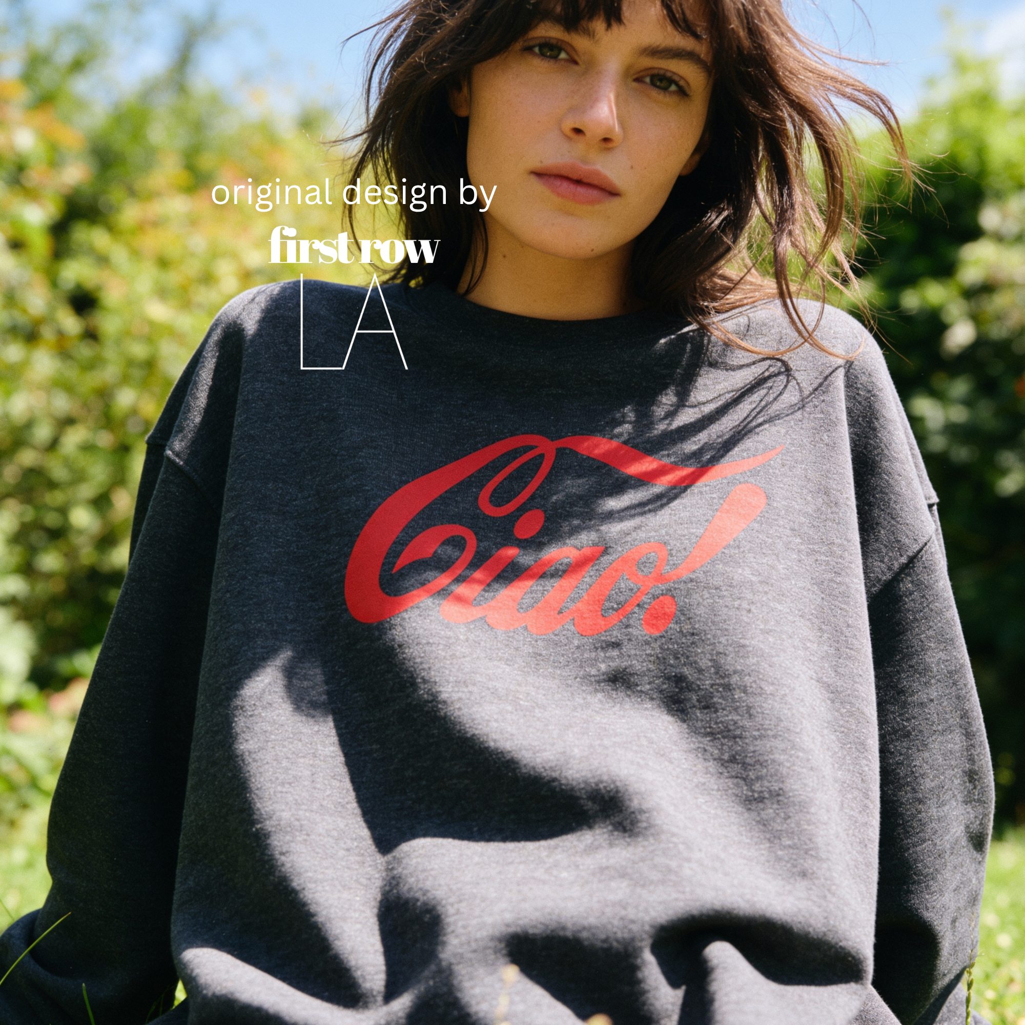 A woman outdoors wearing an oversized dark gray sweatshirt with a large red 'Ciao!' script graphic across the chest. 

Original design and copyright by first row LA.