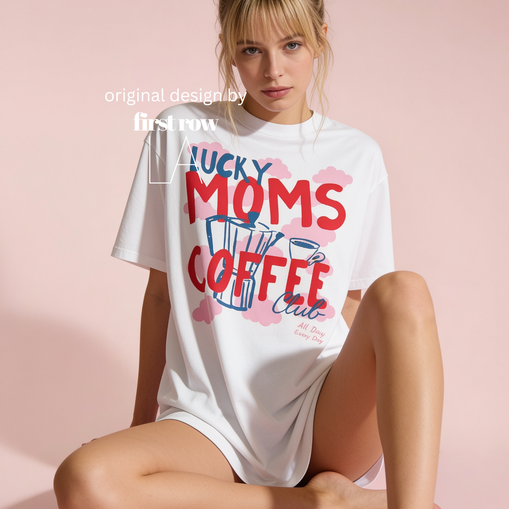 A woman wearing an oversized white graphic T-shirt with the words 'LUCKY MOMS COFFEE Club, All Day, Every Day' in red and blue, on a background of pink clouds. Original design by first row LA.
