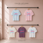  T-shirts in different color options: Chambray light blue, blossom pink, ivory cream, berry purple, and white, each with a blue and pink Aloha, Hawaii with hand drawn graphics of surfboard, flip flops and flowers. Original desing by first row LA.