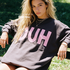 A woman wearing a dark charcoal sweatshirt with large pink 'DUH' lettering across the front.

Original design and copyright by first row LA, August 4th 2026.