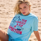 A woman wearing an oversized t-shirt with a blue and pink coffee-themed print that reads 'Pour Yourself a Cup of Ambition'.

Original design and copyright 2026 by first ow LA.