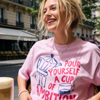 A woman wearing an oversized t-shirt with a blue and pink coffee-themed print that reads 'Pour Yourself a Cup of Ambition'.

Original design and copyright 2026 by first ow LA.