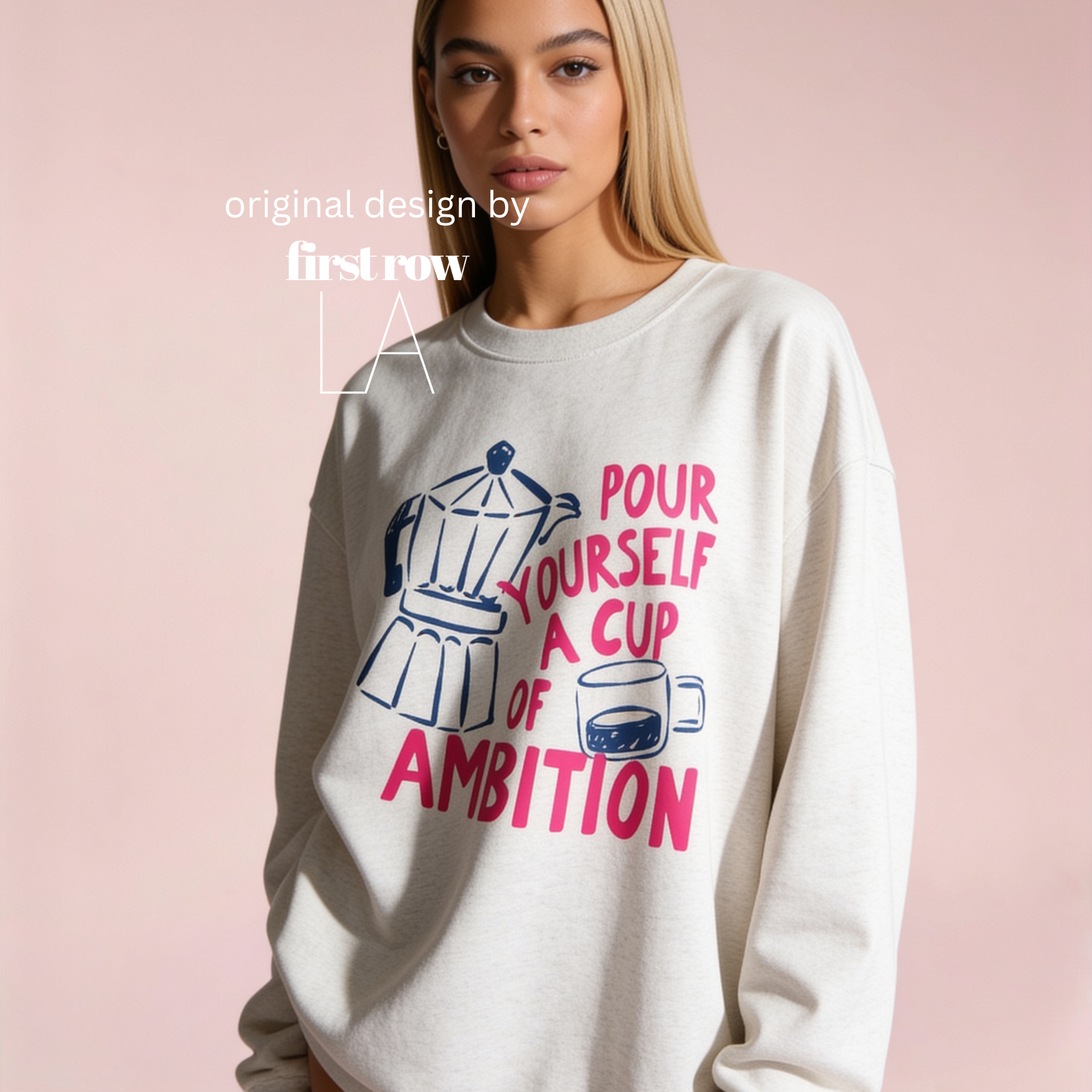 A woman wearing a sweatshirt with a graphic print that reads 'pour yourself a cup of ambition' in pink and blue, alongside a coffee pot and cup illustration. Original design by first row LA.