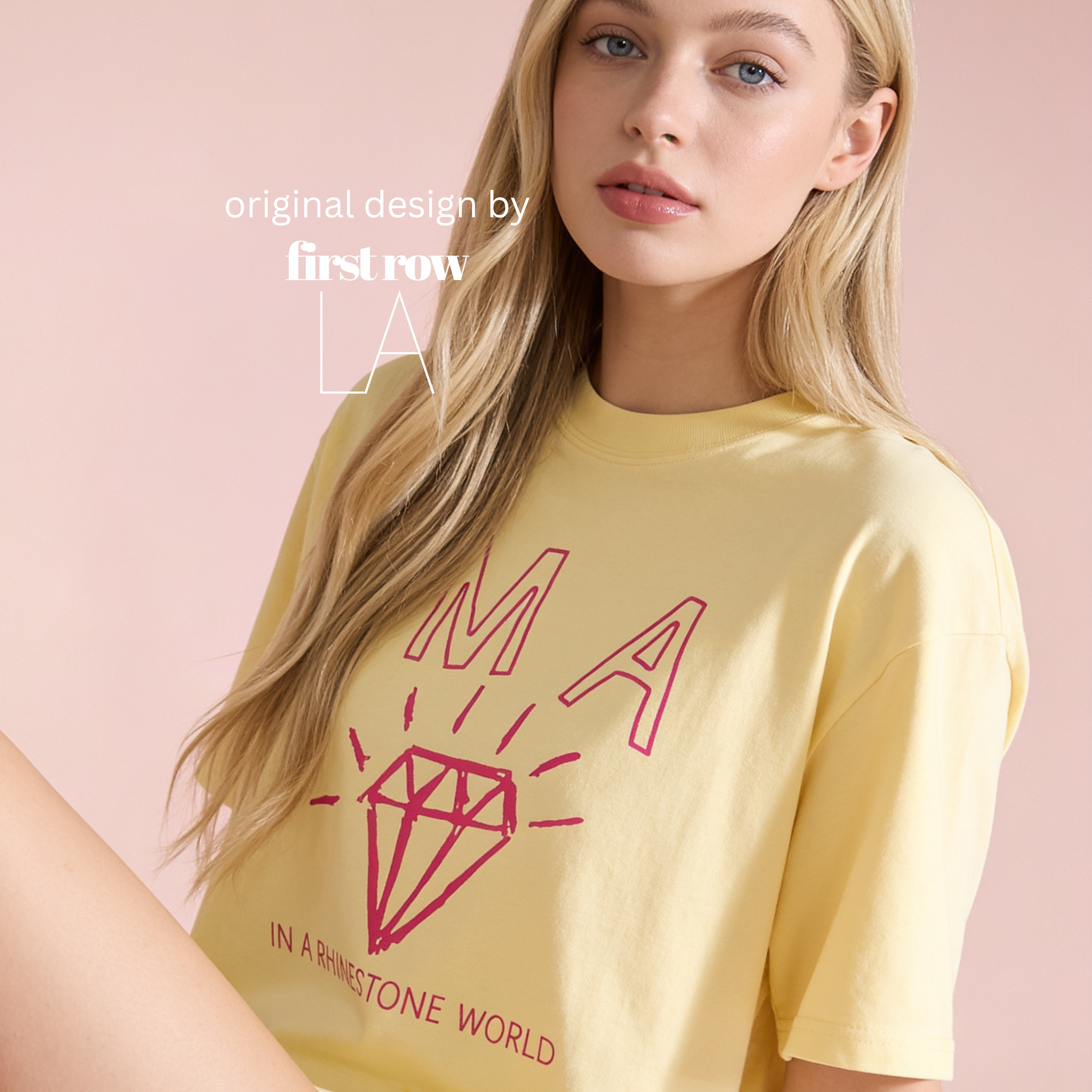 A blonde woman wearing a pale yellow graphic T-shirt with a red outlined diamond and the words 'I'm a diamond in a rhinestone world'. Original design by first row LA.