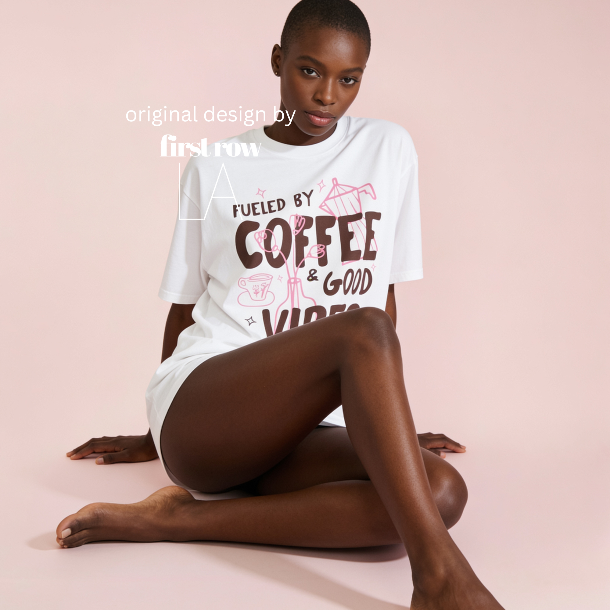 A model wearing a white graphic t-shirt with brown text reading 'FUELED BY COFFEE & GOOD VIBES' and pink floral moka pot and cup drawings. Original design by first row LA.