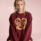 Woman wearing a burgundy sweatshirt with a large gold 'New York' with a pretzel graphic on the front.

Original design and copyright by first row LA.