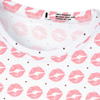 Close-up of a white short-sleeve top with a pink lip and polka dot sprint pattern .

Original design and copyright by first row A.