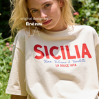 Woman wearing 'SICILIA, Vino, Volcano and Vendetta, LA DOLCE VITA' T-shirt.

Original design and copyright by first row LA 2026.