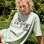 Woman wearing The Wifey Club T-shirt.

Original design and copyright by first row LA 2025.
