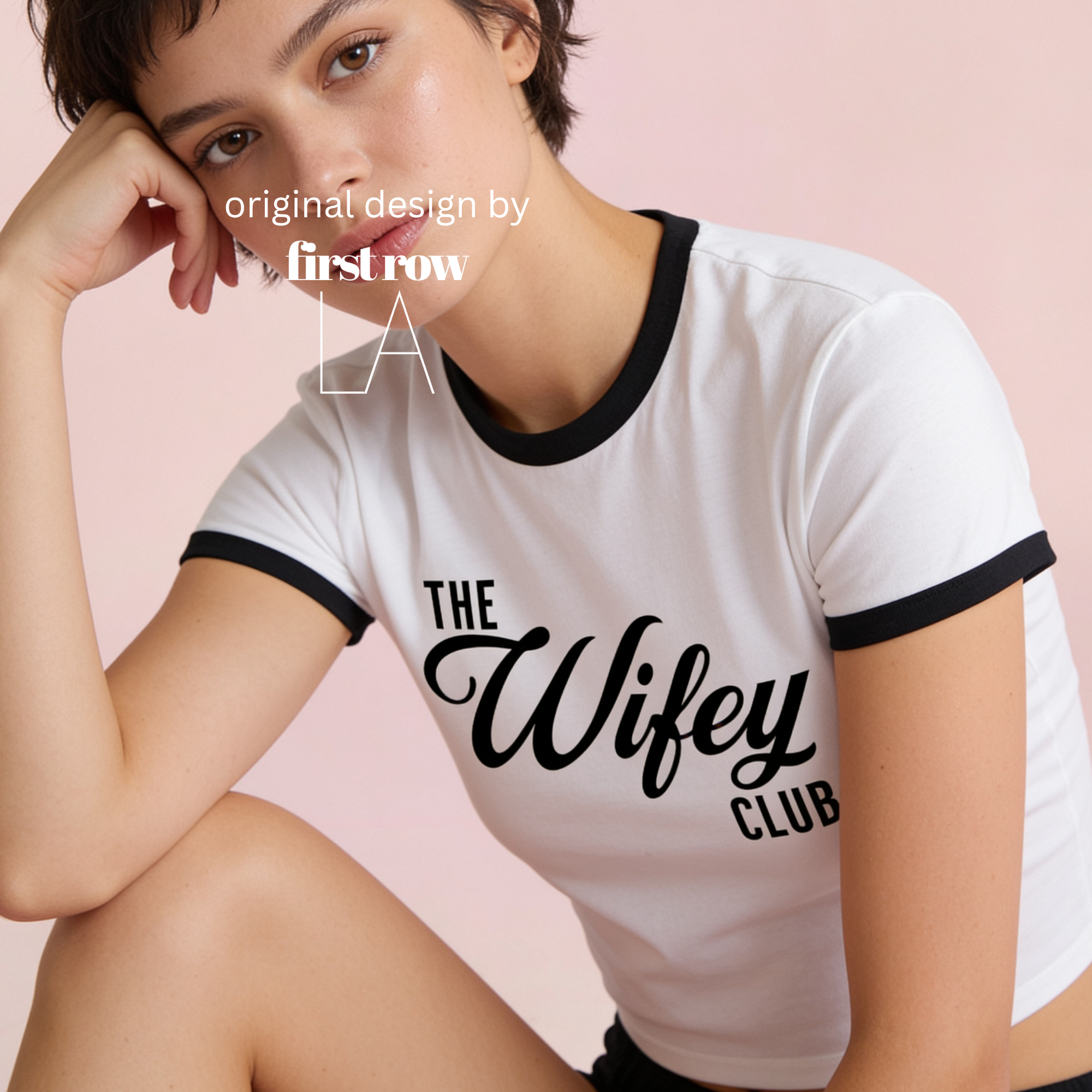 A woman wearing a white cropped ringer T-shirt with black trim and the words 'THE Wifey CLUB' printed in black across the front.

Original design and copyright by first row LA.