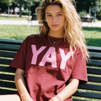 A woman wearing a red t-shirt with pink YAY print.

Original design and copyright by first row LA 2026