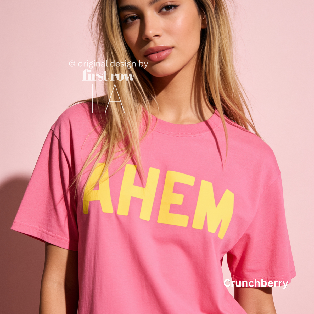 A woman wearing a bright pink T-shirt with the word 'AHEM' printed across the chest in large yellow letters.

Original design and copyright by first row LA, August 4th 2026.