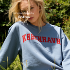 A woman wearing a sweatshirt with 'KØBENHAVN' printed across the chest in dark red collegiate lettering, 

Copenhagen shirt.

Original design and copyright by first row LA.
