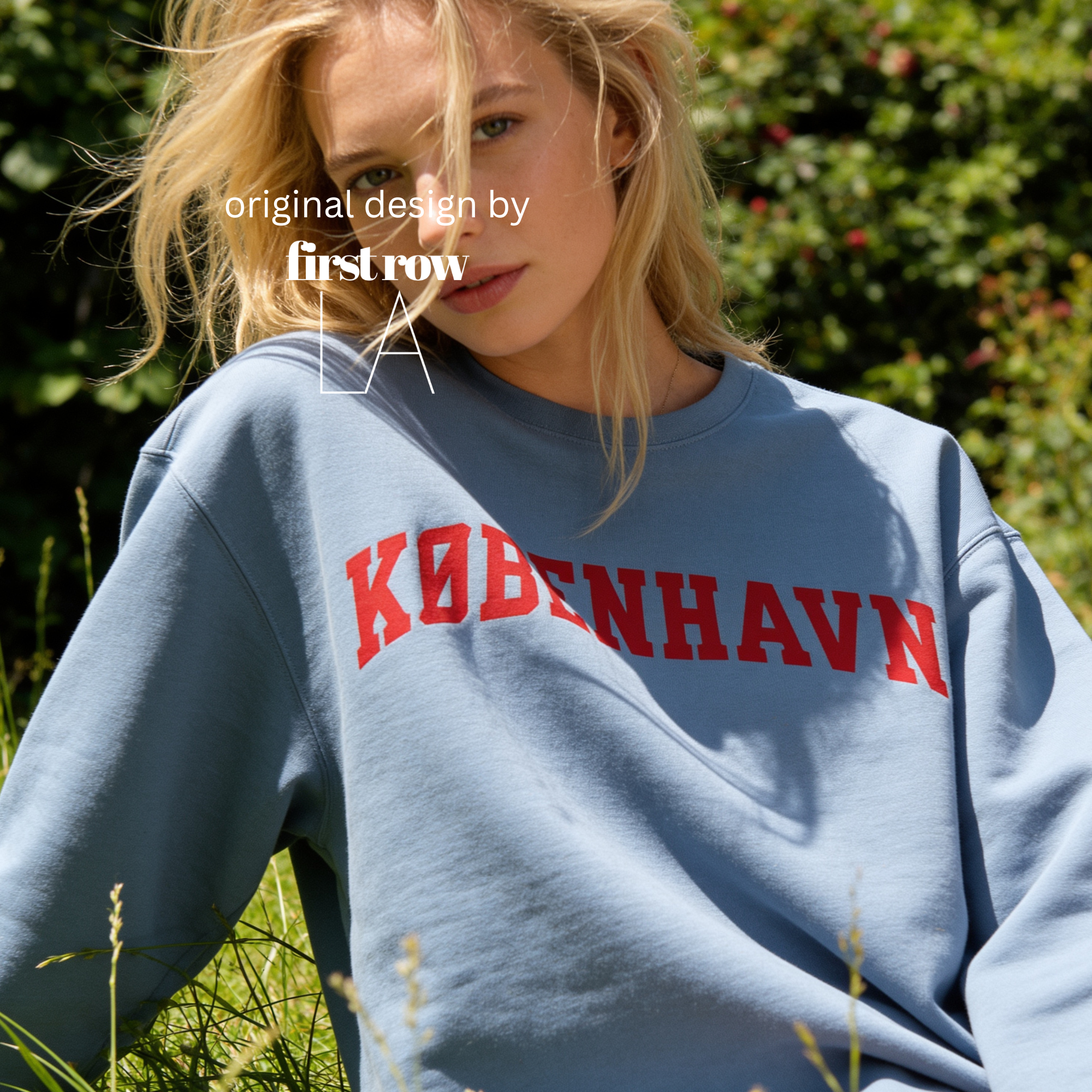 A woman wearing a sweatshirt with 'KØBENHAVN' printed across the chest in dark red collegiate lettering, 

Copenhagen shirt.

Original design and copyright by first row LA.