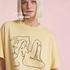 A model with a short blonde bob wears a pale yellow oversized t-shirt featuring a black continuous line art graphic of a woman and her martini.

Original design first row LA.
Copyright lilo on paper 2023.