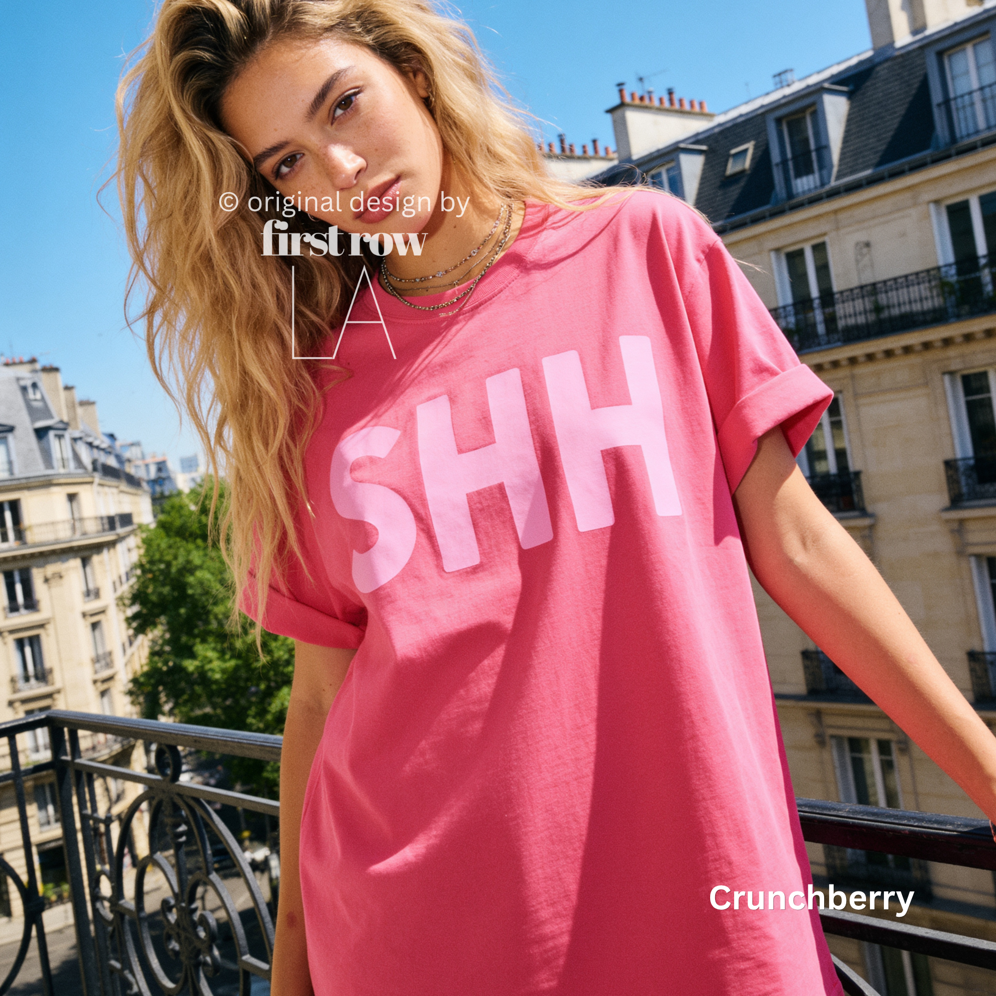 A woman wearing a T-shirt with large white 'SHH' lettering, photographed outdoors on a balcony in Paris.

Original design and copyright by first row LA, August 4th 2026.