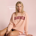 A woman wearing 'HAVNEN' varsity sweatshirt.

Original design and copyright by first row LA.