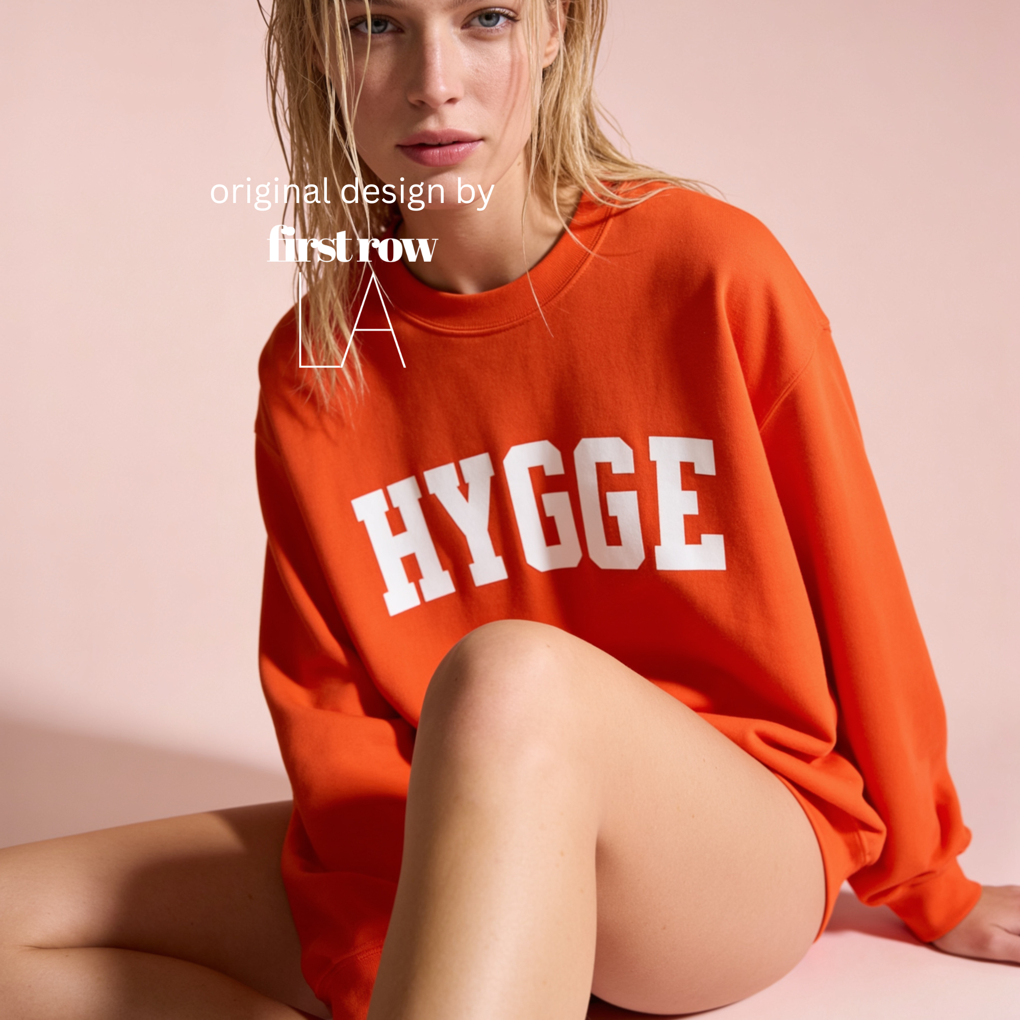 A woman wearing an oversized bright orange sweatshirt with the word 'HYGGE' printed in large white letters across the front.

Original design and copyright by first row LA.
