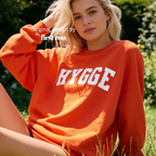 A woman outdoors wearing a bright orange sweatshirt with the word 'HYGGE'.

Original design and copyright by first row LA.