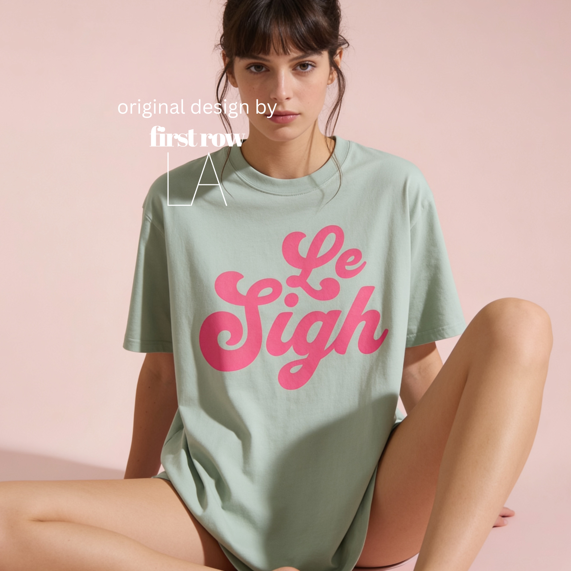 A woman wearing an oversized sage green t-shirt with 'Le Sigh' printed in pink.

Original design and copyright by first row LA 2025.