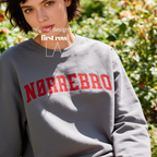 A woman wearing an oversized sweatshirt with 'NØRREBRO' printed across the chest in dark red collegiate lettering.

Original design and copyright by first row LA.