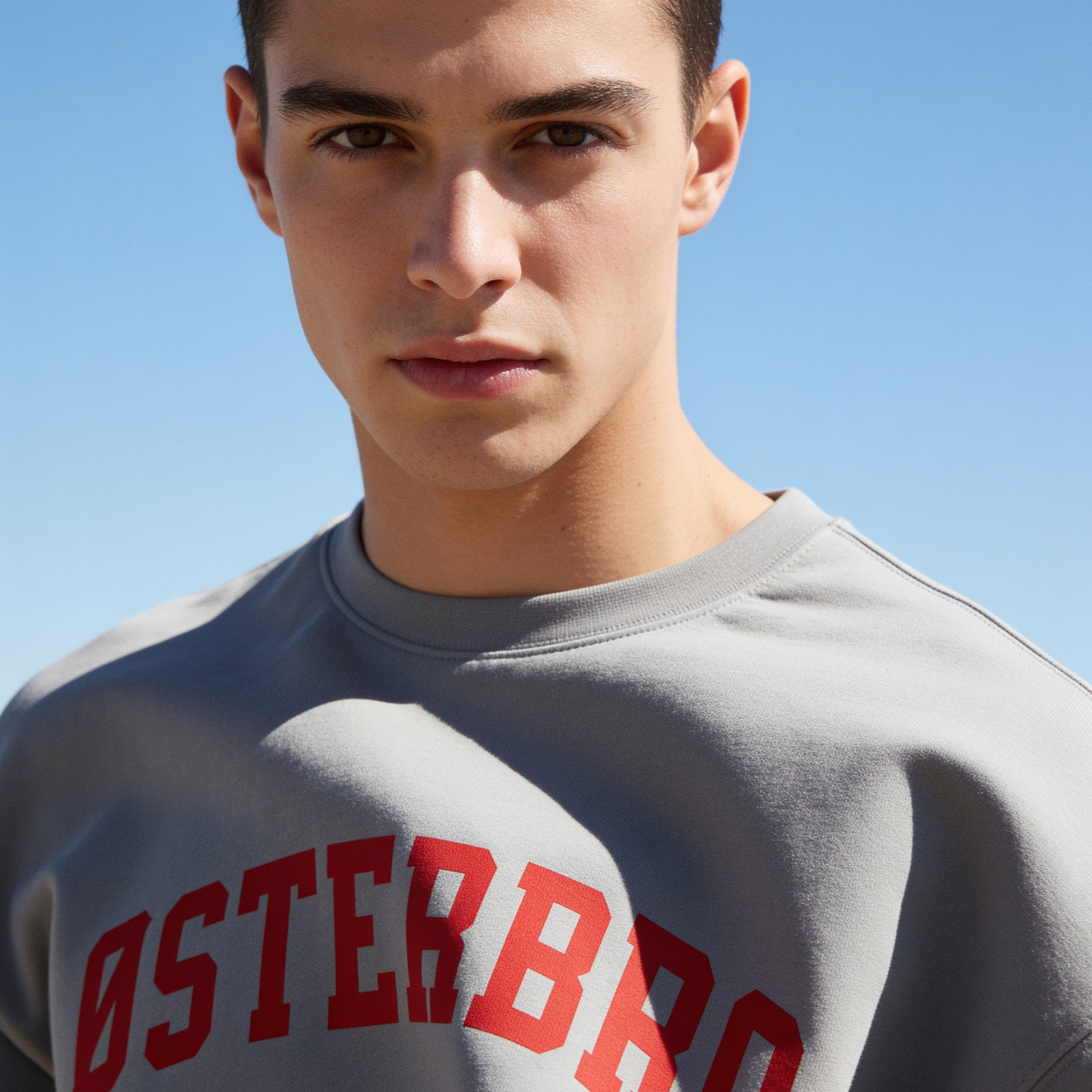 Man wearing a crewneck sweatshirt with 'ØSTERBRO' printed in dark red across the chest.

Original design and copyright by first row LA.