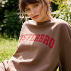 A woman wearing a espresso brown crewneck sweatshirt with 'ØSTERBRO' printed in dark red across the chest.

Original design and copyright by first row LA.