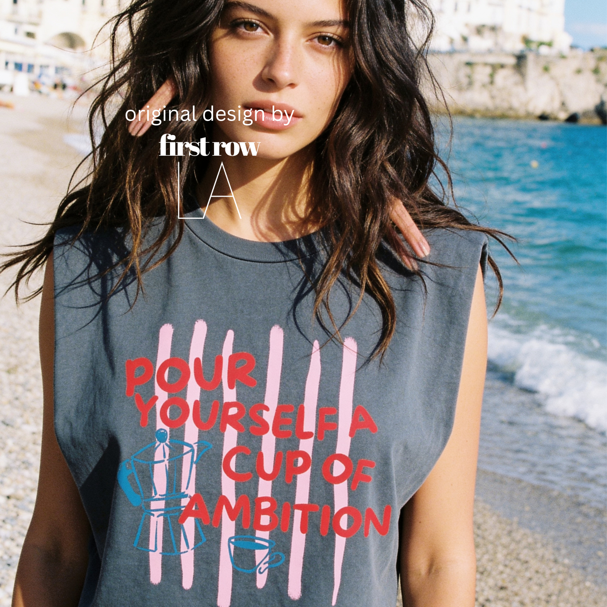 A woman wearing a sleeveless cream-colored t-shirt with a graphic print that reads 'POUR YOURSELF A CUP OF AMBITION' in red, decorated with pink vertical stripes, a blue moka pot, and a small coffee cup. 

Original design and copyright by first row LA.