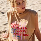 A woman wearing a sleeveless cream-colored t-shirt with a graphic print that reads 'POUR YOURSELF A CUP OF AMBITION' in red, decorated with pink vertical stripes, a blue moka pot, and a small coffee cup. 

Original design and copyright by first row LA.