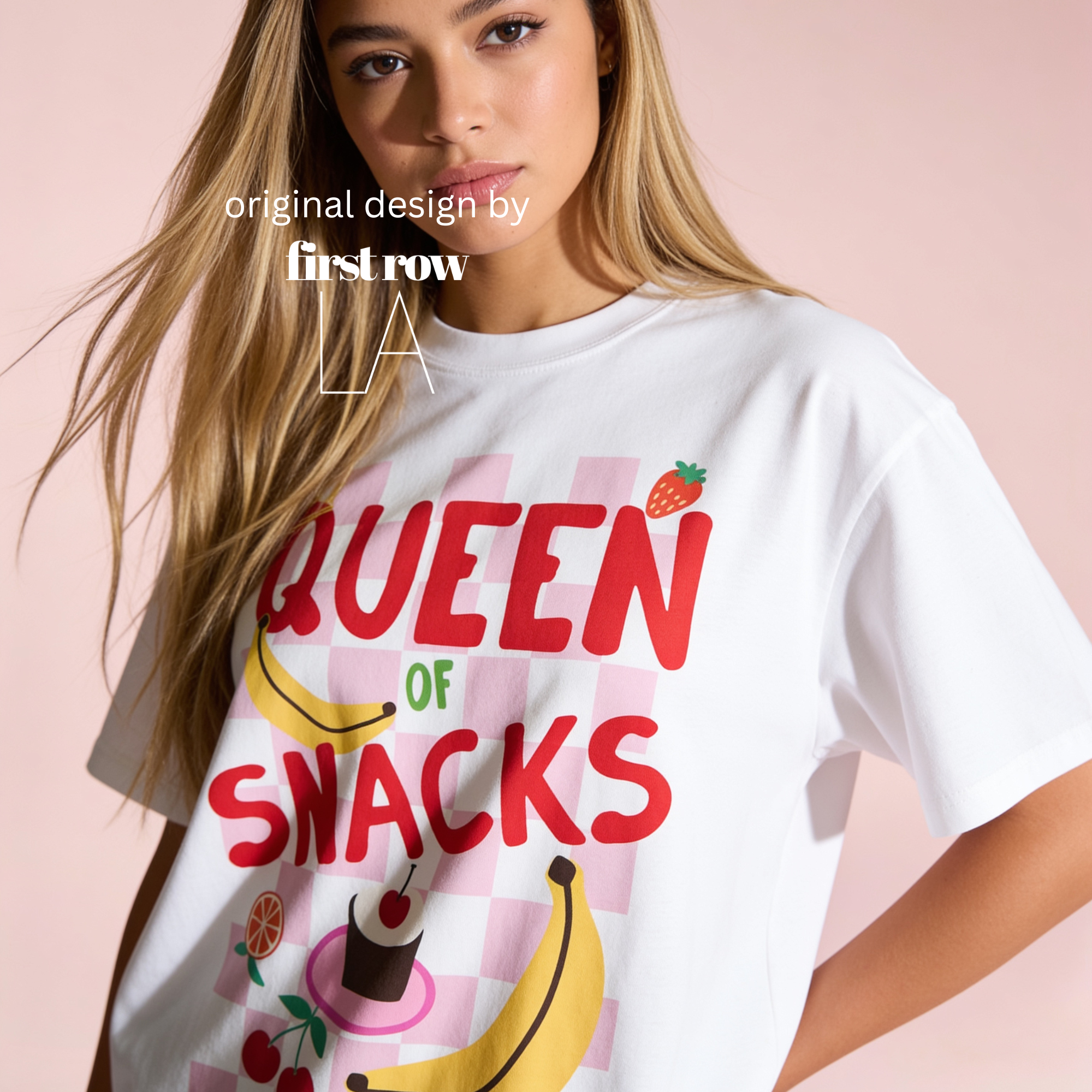 A woman wearing a white graphic T-shirt with the phrase 'QUEEN OF SNACKS' in large red letters over a pink checkered background, with illustrations of a banana, strawberry, orange, and a cupcake. 

Original design and copyright by first row LA.