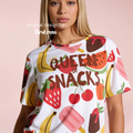 Woman wearing Queen of Snacks T-shirt. All over print with strawberries, watermelon, cherries, bananas, and popsicles. 

Original design and copyright by first row LA 2026.