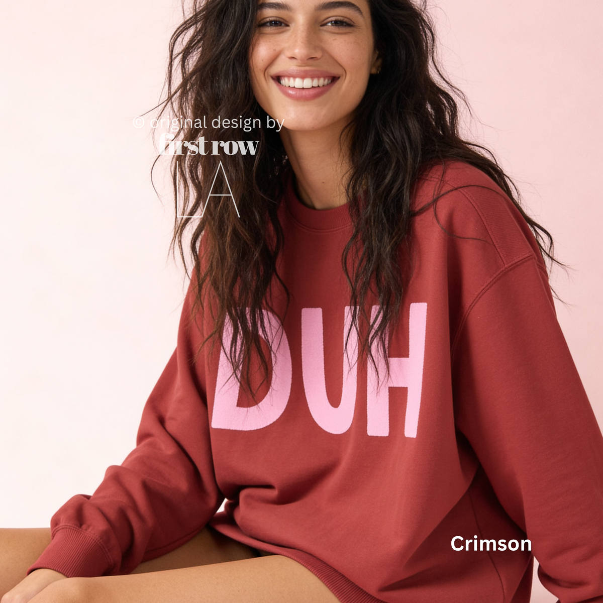 A woman wearing a crewneck sweatshirt in a deep crimson color with the word 'DUH' printed across the chest in light pink. 

Original design and copyright by first row LA, August 4th 2026.
