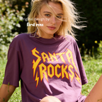 A woman wearing 'SANTA ROCKS' unisex funny Christmas T-shirt.

Original design and copyright by first row LA.