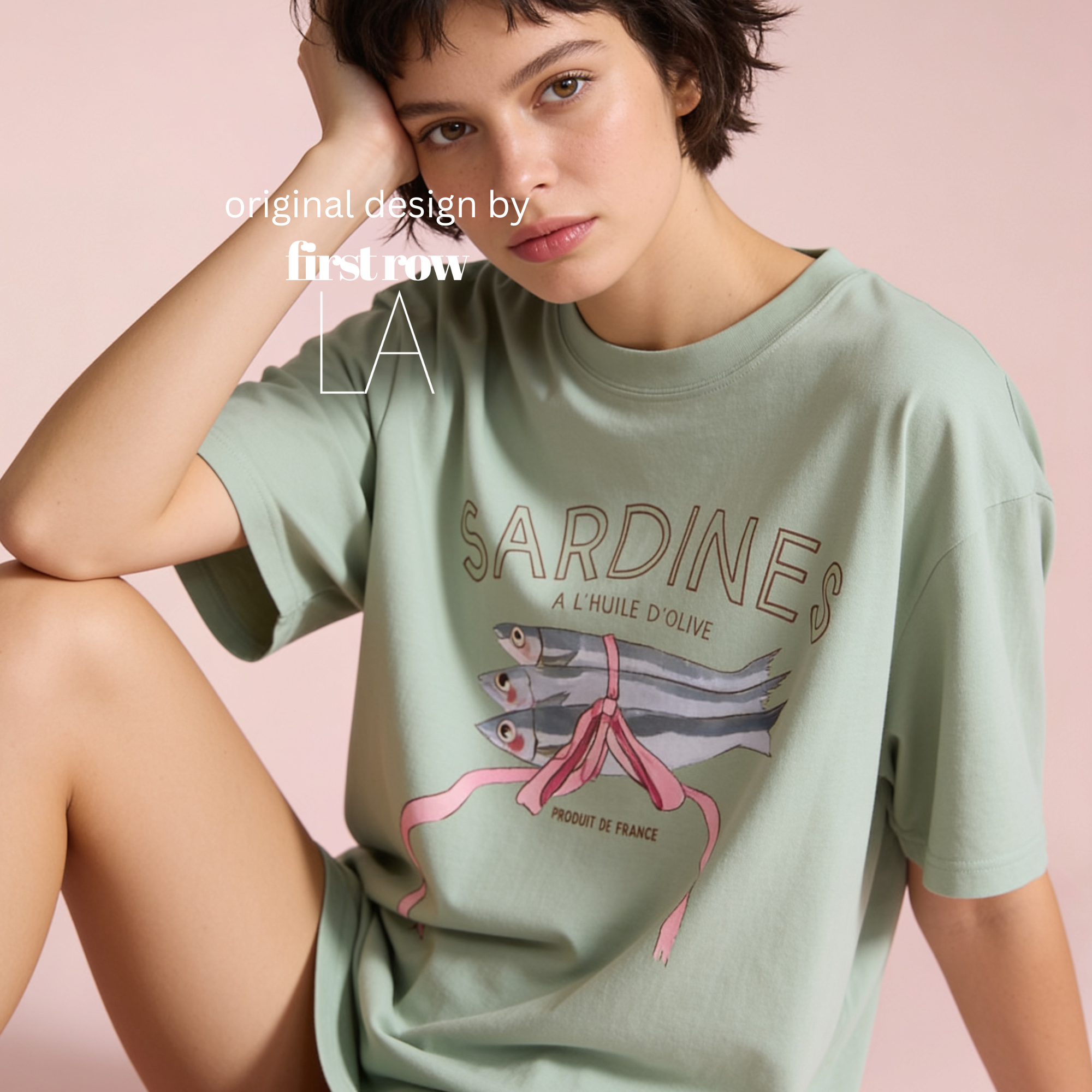 Woman wearing bay green SARDINES T-shirt. Produit de France.

Original design by first row LA.
Copyright by Lilo on Paper 2026.