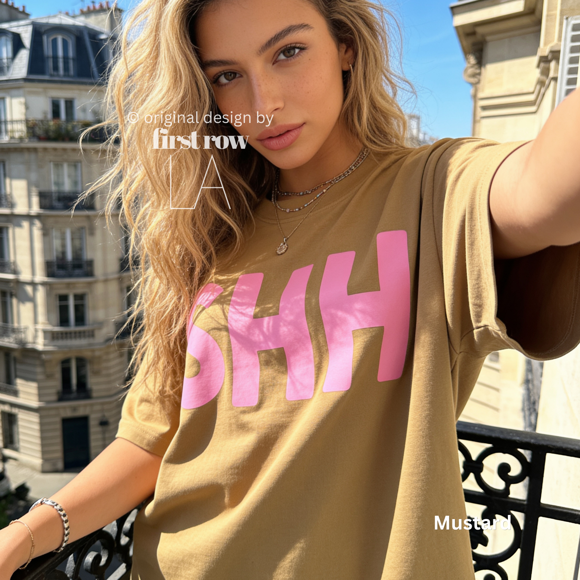 A woman wearing a T-shirt with large pink 'SHH' lettering on the front, photographed on a balcony in Paris.

Original design and copyright by first row LA, August 4th 2026.