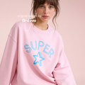 A woman wearing a light pink crewneck sweatshirt with 'SUPER' and a star outlined in blue on the front.

Original design and copyright by first row LA.